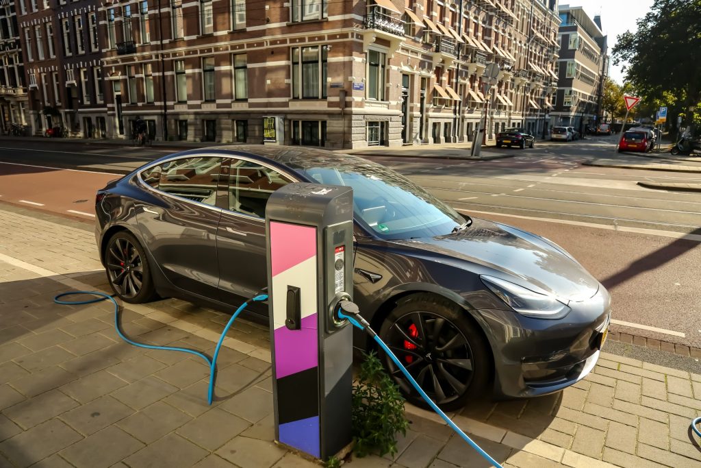 Une Tesla garé, en train d'être recharchée par une borne de recharche électrique